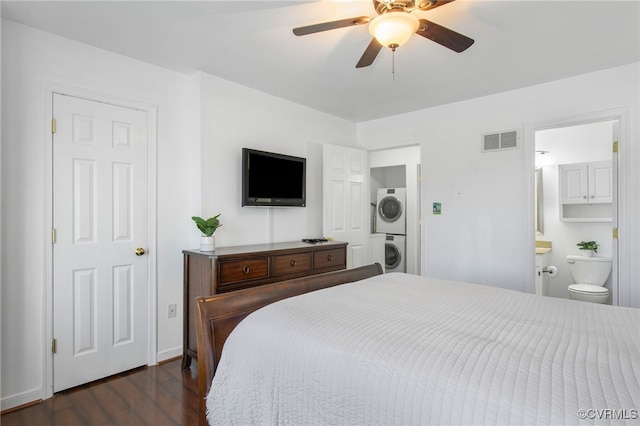 bedroom with stacked washer and dryer, visible vents, ensuite bath, ceiling fan, and dark wood-type flooring