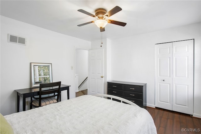 bedroom with dark wood-style flooring, a closet, visible vents, and a ceiling fan