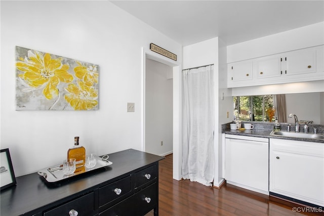 kitchen featuring dark wood-style flooring, a sink, white cabinetry, dishwasher, and dark countertops