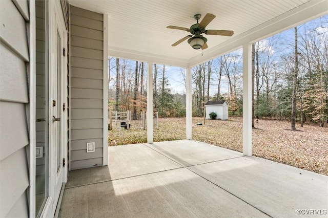 view of patio featuring a ceiling fan, an outbuilding, and a shed