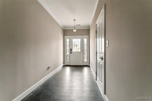 foyer entrance with dark wood-style floors, visible vents, baseboards, and ornamental molding