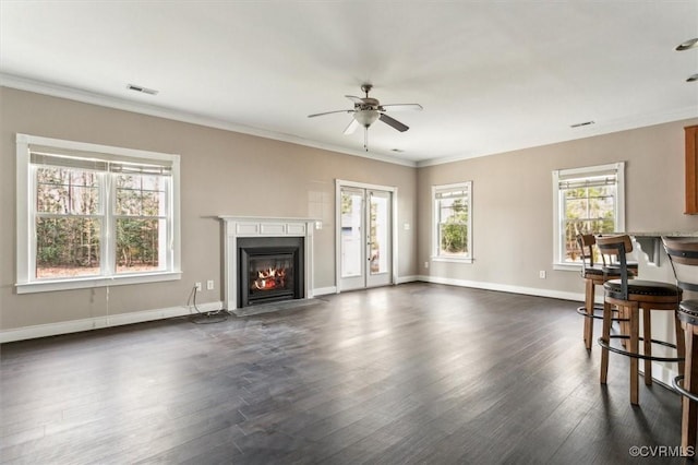 living area with visible vents, dark wood finished floors, baseboards, a fireplace with flush hearth, and ornamental molding