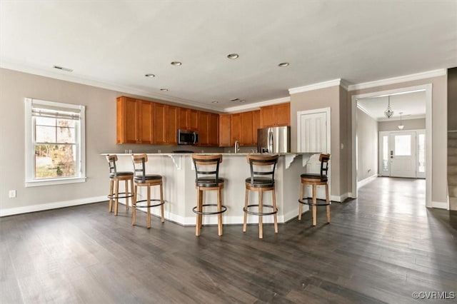 kitchen featuring plenty of natural light, a kitchen bar, visible vents, and stainless steel appliances