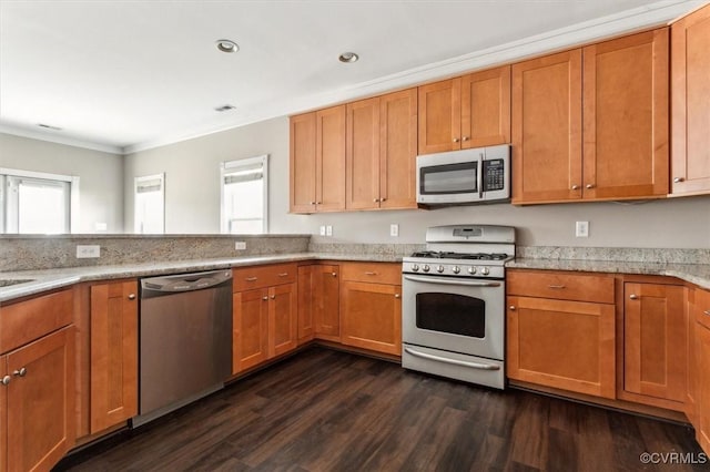 kitchen with ornamental molding, appliances with stainless steel finishes, dark wood-type flooring, and brown cabinets