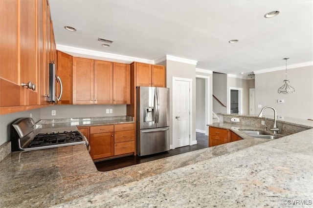 kitchen featuring visible vents, brown cabinets, stainless steel appliances, crown molding, and a sink