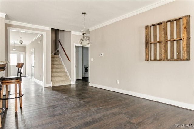 empty room featuring dark wood-style floors, stairway, ornamental molding, washer / dryer, and baseboards