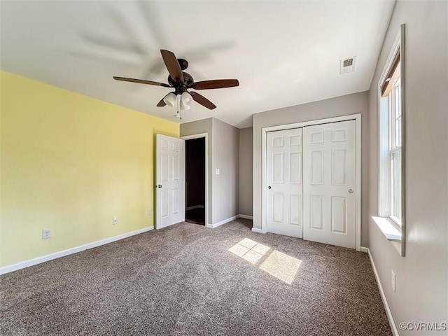 unfurnished bedroom with baseboards, multiple windows, visible vents, and carpet flooring