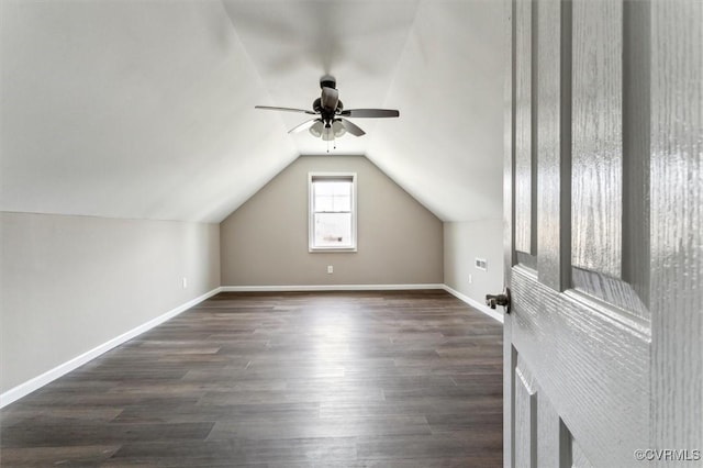 additional living space with lofted ceiling, baseboards, and dark wood finished floors