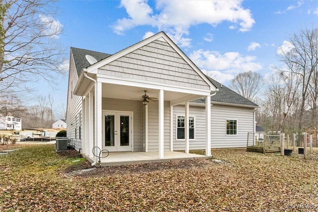 rear view of house featuring cooling unit, a shingled roof, a ceiling fan, french doors, and a patio area