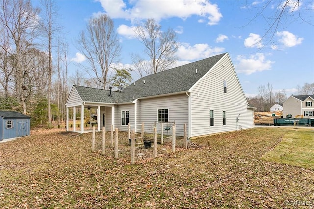 rear view of property featuring a storage unit, a lawn, a patio area, ceiling fan, and an outdoor structure