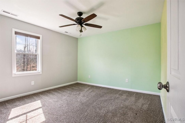 carpeted empty room featuring a ceiling fan, visible vents, and baseboards