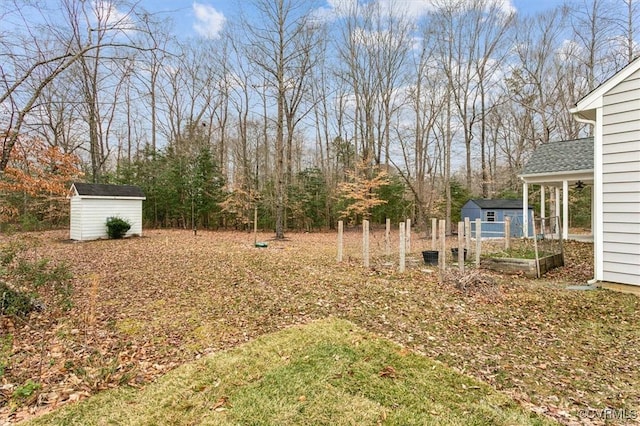 view of yard featuring a garden, an outdoor structure, and a storage unit