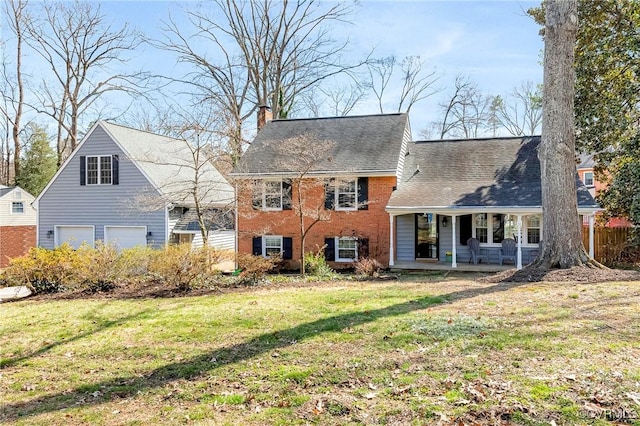 back of property with roof with shingles, brick siding, a chimney, and a lawn