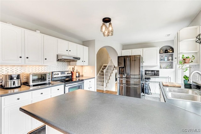 kitchen featuring arched walkways, white cabinets, appliances with stainless steel finishes, under cabinet range hood, and open shelves