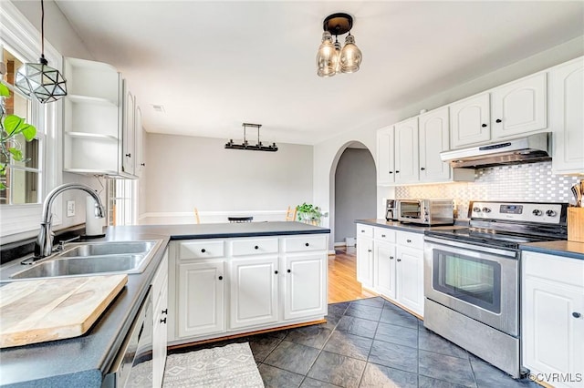 kitchen with arched walkways, electric range, a sink, a peninsula, and under cabinet range hood