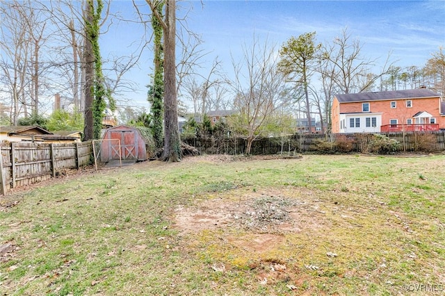 view of yard with a storage unit, an outdoor structure, and a fenced backyard