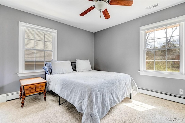 bedroom with carpet, visible vents, ceiling fan, and a baseboard radiator