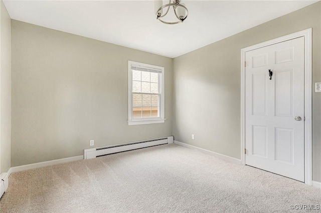 spare room featuring baseboards, a baseboard heating unit, and carpet flooring