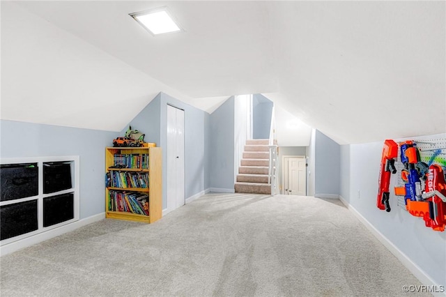 interior space with carpet floors, stairs, baseboards, and vaulted ceiling