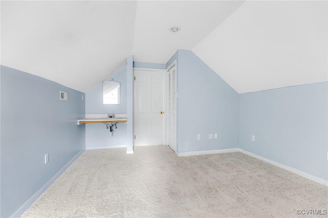 bonus room featuring carpet floors, baseboards, a sink, and lofted ceiling