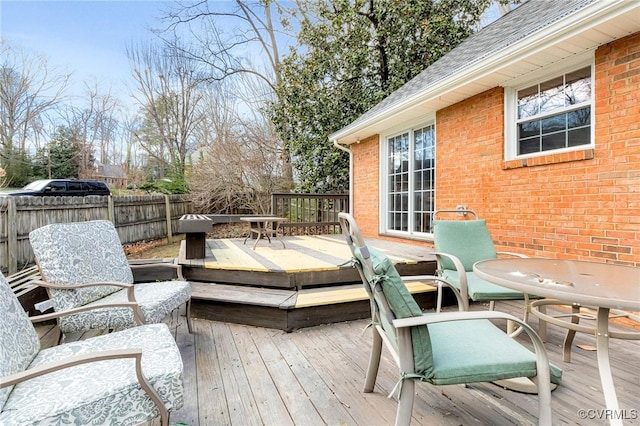 wooden terrace featuring outdoor dining area and fence