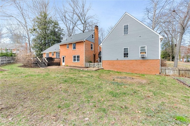 back of property with a deck, brick siding, and a fenced backyard