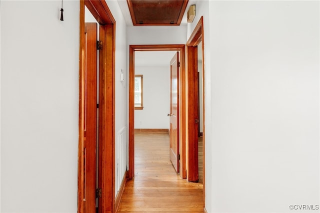 hallway featuring baseboards and light wood-style floors