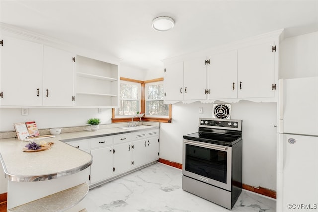 kitchen featuring marble finish floor, stainless steel electric stove, a sink, and freestanding refrigerator