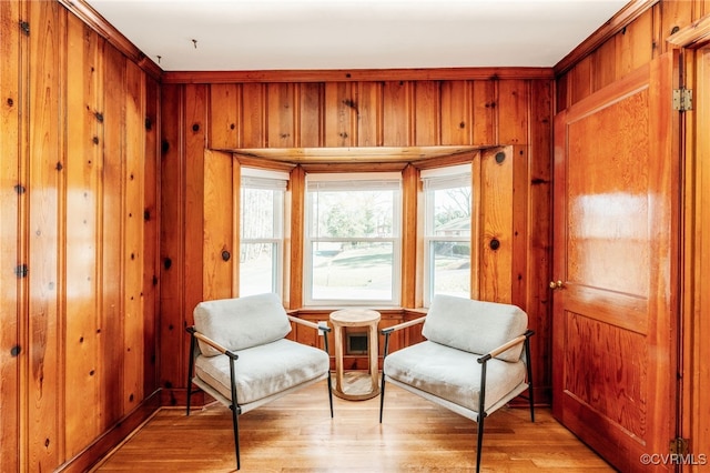 sitting room featuring light wood-style floors and wooden walls