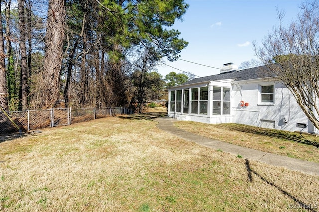 view of yard with a sunroom and fence