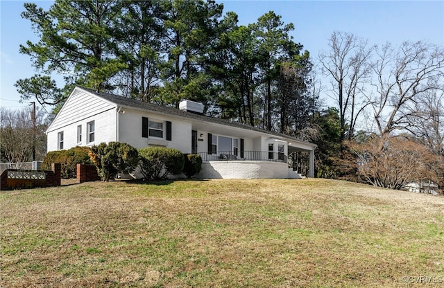 ranch-style house featuring brick siding, a chimney, and a front lawn