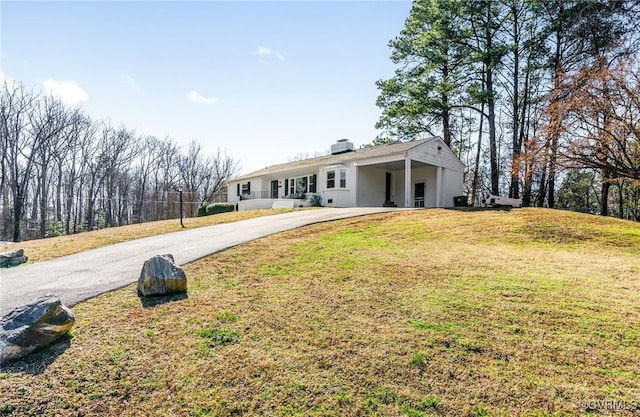 view of front of home with a front yard, driveway, and a chimney