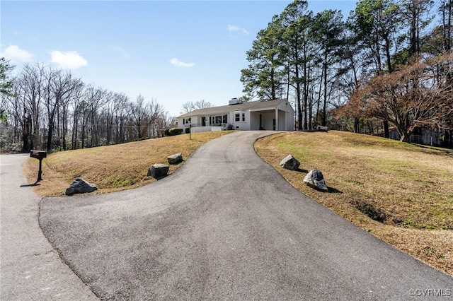 ranch-style home featuring driveway and a front yard