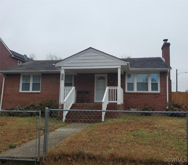 view of front of house with brick siding, a fenced front yard, and a front lawn