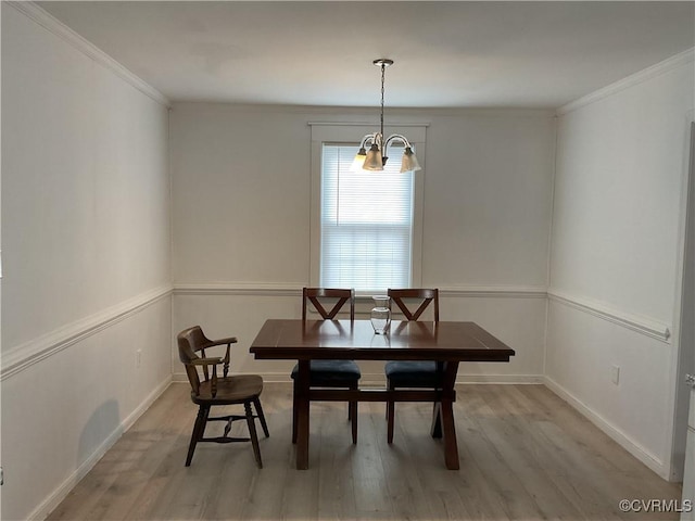 dining area featuring baseboards, crown molding, and light wood finished floors