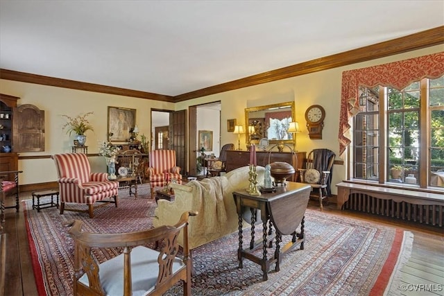 living area with wood-type flooring, radiator, and ornamental molding