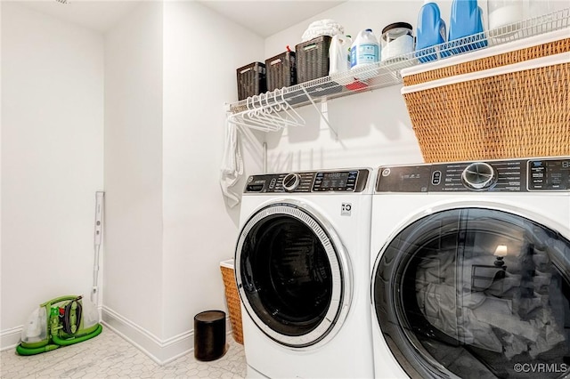 laundry room featuring laundry area, baseboards, separate washer and dryer, and tile patterned floors