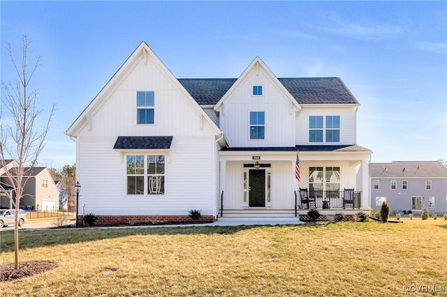 modern farmhouse style home with covered porch, a shingled roof, and a front yard