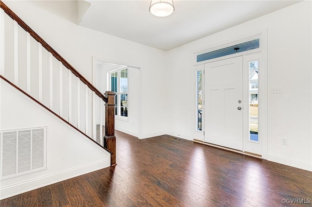 foyer featuring stairs, visible vents, baseboards, and wood finished floors