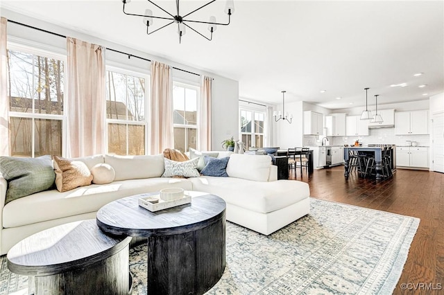 living area featuring dark wood-type flooring, recessed lighting, and an inviting chandelier