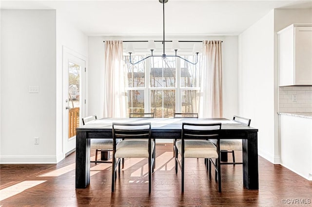 dining area featuring dark wood finished floors and baseboards