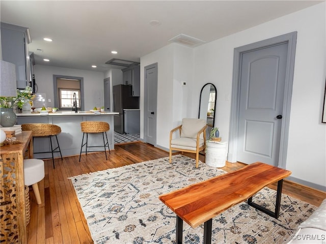 living area with light wood-style floors, baseboards, and recessed lighting