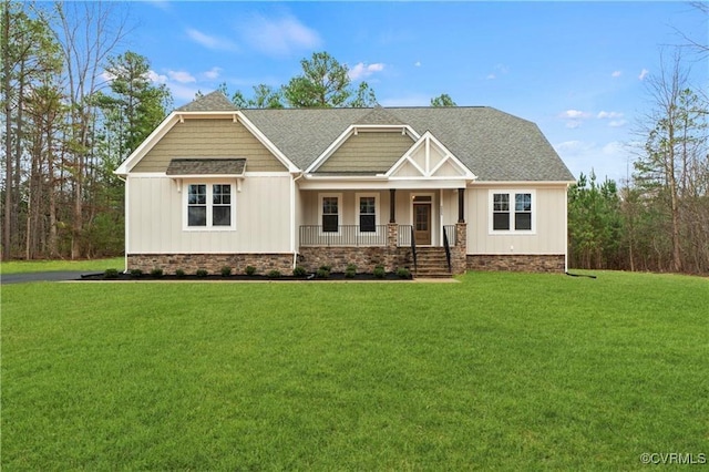 craftsman house featuring covered porch, a shingled roof, a front lawn, and board and batten siding