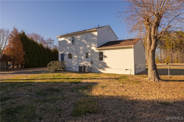 view of side of home with central AC, a yard, crawl space, and fence