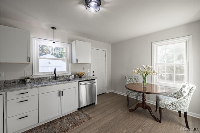 kitchen featuring dark wood-style flooring, light stone countertops, stainless steel dishwasher, white cabinetry, and a sink