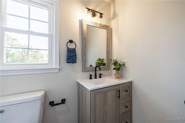 half bathroom featuring vanity and toilet