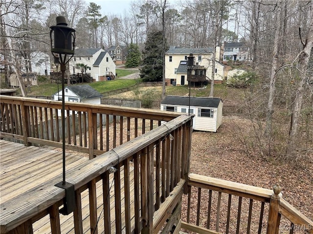 wooden deck with a storage shed, a residential view, and an outdoor structure