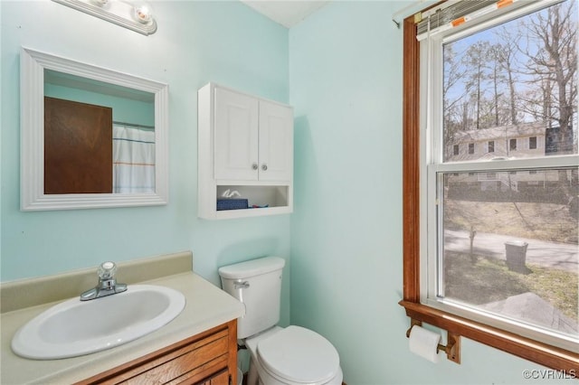 full bath featuring a healthy amount of sunlight, vanity, and toilet