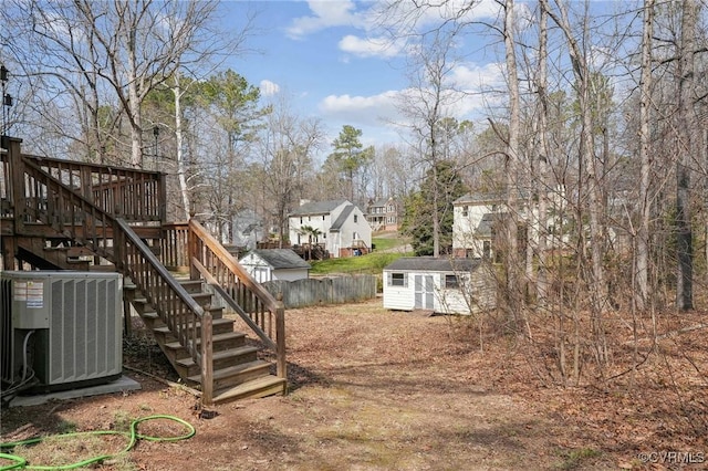 view of yard with central air condition unit, fence, a shed, an outdoor structure, and stairs