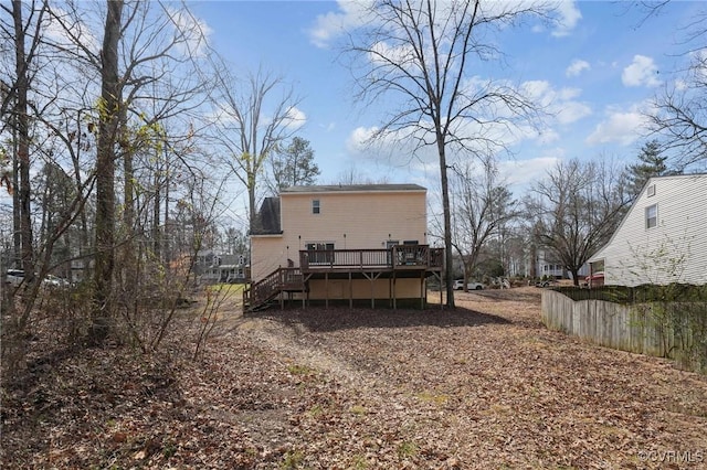 rear view of property with a deck, stairs, and fence